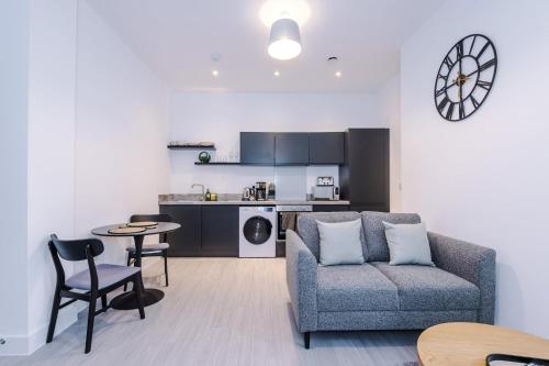 a living room with a couch and a table and a kitchen at Modern 1BR Apartment in Central Warrington in Warrington