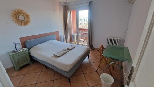 une petite chambre avec un lit et une table dans l'établissement Grand et Sapcieux T4 proche centre-ville, à Montpellier