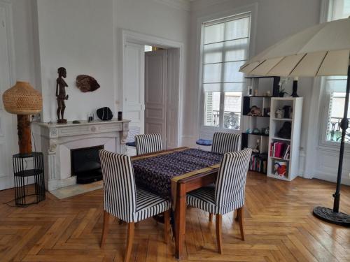 une salle à manger avec une table et des chaises et une cheminée dans l'établissement GRANDE chambre à SAINT-ETIENNE CENTRE chez l'habitant, à Saint-Étienne