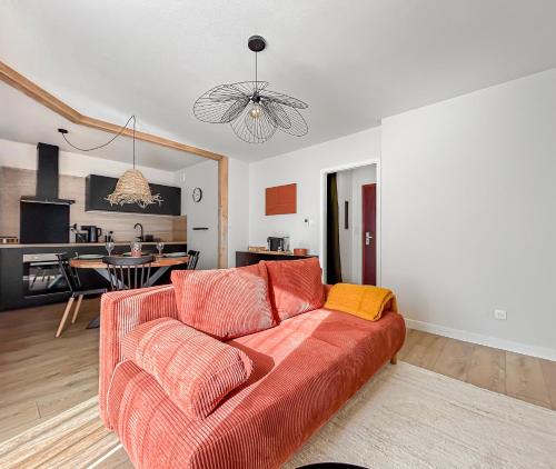 ein Wohnzimmer mit einem roten Sofa und einer Küche in der Unterkunft Saint-Louis - Cozy Apartment Close to Switzerland & Train Station in Saint-Louis