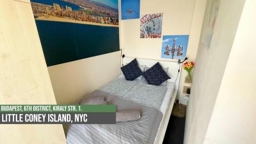 a small bedroom with a bed with a poster on the wall at Little Americas New York Rooftop Terrace in Budapest