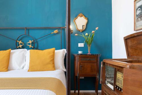 a bedroom with blue walls and a bed with yellow pillows at 900 - Guest House in Livorno
