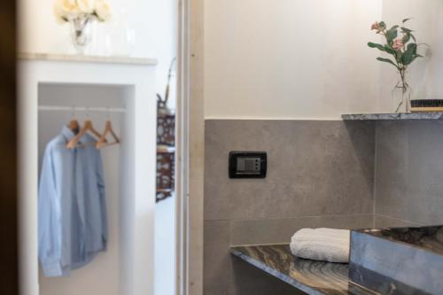 a bathroom with a counter with a blue robe at 900 - Guest House in Livorno