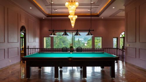 a pool table in a room with a chandelier at Golden Goose Villas in Bedugul