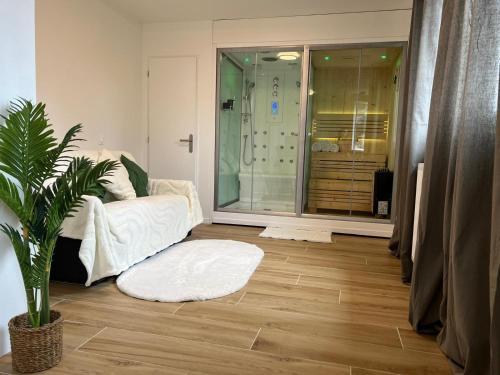 a living room with a shower and a white couch at L'harmonie d'Eden Harmony of Eden in Sainte-Geneviève-des-Bois