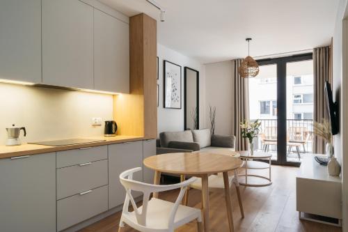 a kitchen and living room with a table in a kitchen at Native Apartments Kościuszki 39I29 in Kraków