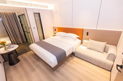 a bedroom with a large bed and a couch at 逸方里广州北京路海珠广场地铁站店 in Guangzhou