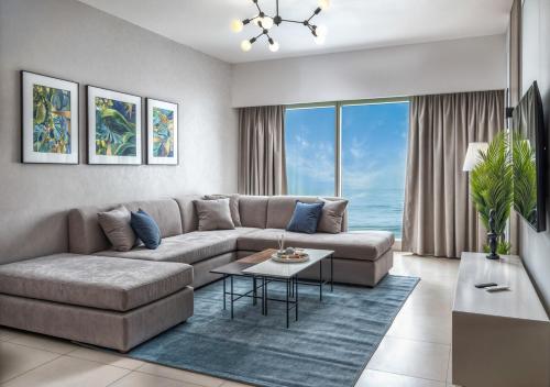 a living room with a couch and a table at Desert Key - Platinum Apartments in Gate Tower, Al Reem Island in Abu Dhabi