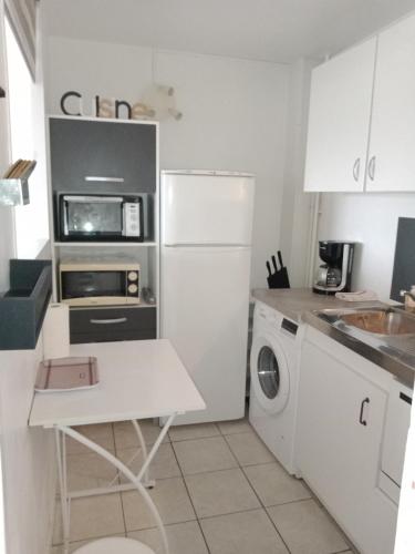Il comprend une cuisine équipée d'un réfrigérateur blanc et d'un lave-linge/sèche-linge. dans l'établissement Appartement, Résidence Grand Pavois, 28 rue Anatole France, lumineux, plein centre, tout à pied, parking privé, ascenseur, arrivée autonome,, au Havre