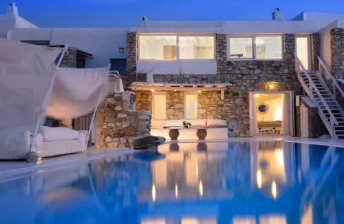 a swimming pool in front of a house at Paradisiacal Villa with Pool and Sea View in Mykonos in Agios Ioannis Mykonos
