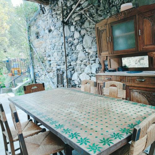 d'une salle à manger avec une table, des chaises et une télévision. dans l'établissement Gîte et jardin en bord de rivière, à Saumane