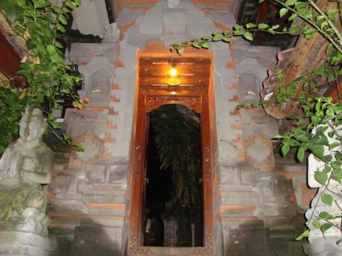 a hallway in a temple with a plant in it at Gusti Home Stay Ubud in Ubud