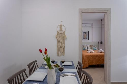 a dining room with a table with flowers and a bed at Avra 4 amazing house by the sea in Tsoútsouros