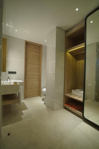 a bathroom with a sink and a toilet and a mirror at Harris Suites Puri Mansion in Jakarta