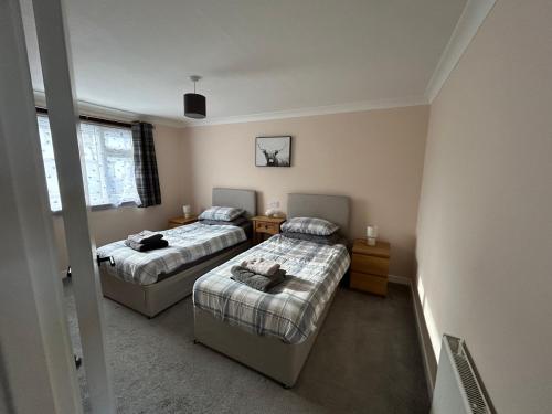 a bedroom with two beds and a window at Viewlands house in Auchterarder