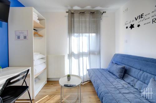 un salon avec un canapé bleu et une table dans l'établissement Terre - Proche A 10 - 2V - Parking, à Saint-Pierre-des-Corps