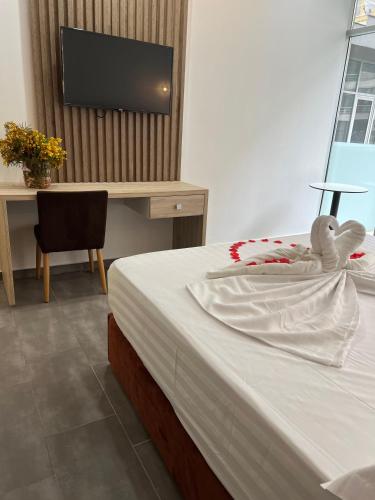 a bedroom with a bed with a stuffed animal on it at Ajsel Hotel in Durrës