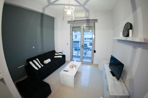 a living room with a black couch and a table at Lak Peristeri Homes 50m from metro station in Athens