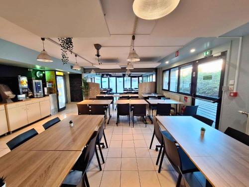 a restaurant with wooden tables and chairs in a cafeteria at CIS de Champagne - Ethic Etapes in Reims