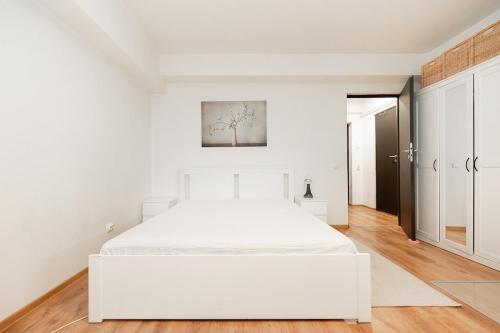 - une chambre blanche avec un grand lit blanc dans l'établissement The Shiny Apple, à Dobroeşti