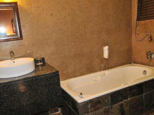 a bathroom with a sink and a bath tub at 2Ten Hotel in Sibasa
