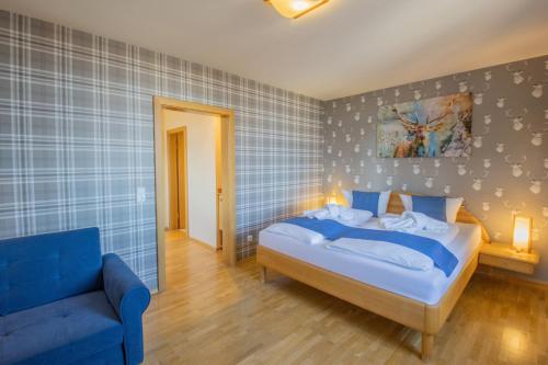a bedroom with a bed and a blue couch at Ferien Residenz Thüringer Wald in Masserberg