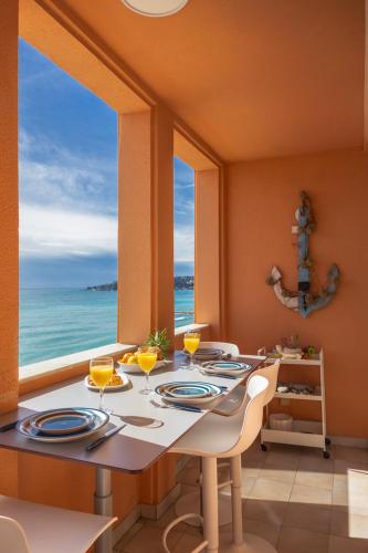 une salle à manger avec une table avec vue sur l'océan dans l'établissement Le Bristol, vue mer panoramique, terrasse, parking, à Menton