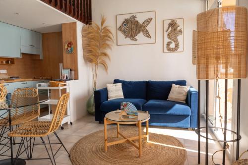 un salon avec un canapé bleu et une table dans l'établissement Le Bristol, vue mer panoramique, terrasse, parking, à Menton