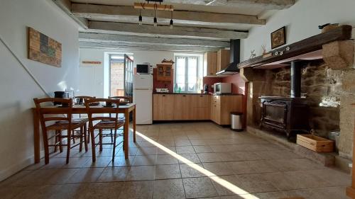 une cuisine avec une table, des chaises et une cuisinière dans l'établissement la Casetta, à Pontarion