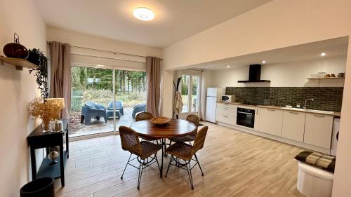 une cuisine et une salle à manger avec une table et des chaises dans l'établissement Ilha Grande, maison de campagne, à Ponthoile