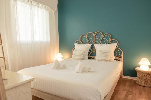 une chambre avec un grand lit blanc avec deux oreillers dans l'établissement Le Bristol, vue mer panoramique, terrasse, parking, à Menton