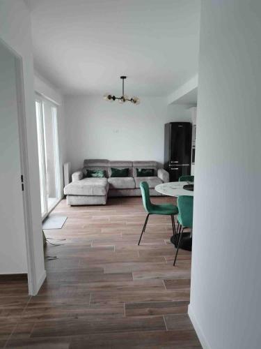 un salon avec un canapé, une table et des chaises dans l'établissement T2 centre ville Anglet dernier étage parking en sous-sol WIFI smart TV serviettes et draps inclus, à Anglet