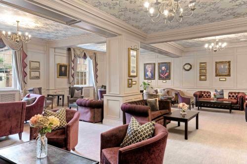 a large living room with chairs and tables and a chandelier at Dukes Head Hotel Kings Lynn in Kings Lynn