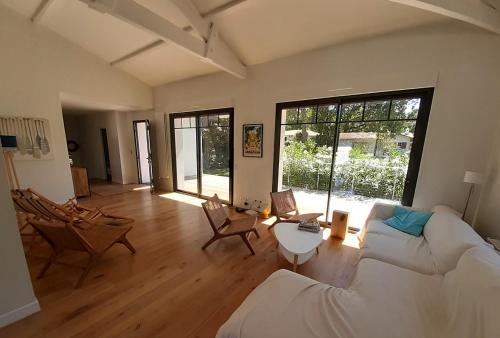 un salon avec un canapé blanc et une table dans l'établissement Belle Villa moderne 6 chambres et piscine chauffée- au Moulleau, à Arcachon