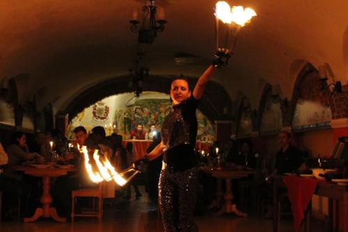 a woman is standing in a room with fire at Aranykorona Hotel in Miskolc