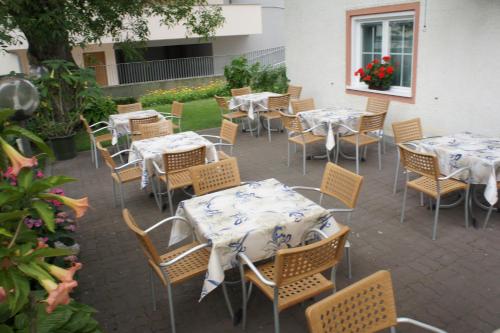 an outdoor patio with tables and chairs with flowers at Pension Pernthaler in Silandro