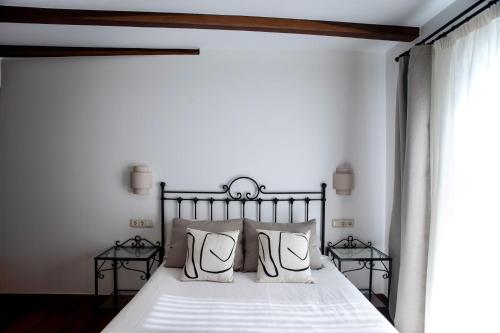 a bedroom with a bed with white sheets and pillows at Katrapona in Getaria