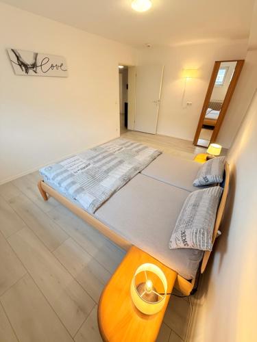 a bedroom with a large bed and a wooden table at Casa Grande mit 3 Apartments in Rastatt