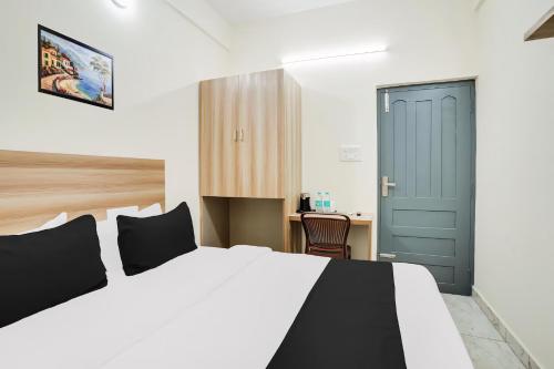 a bedroom with a bed with a blue door and a desk at RG Suites HSR layout in Bengaluru