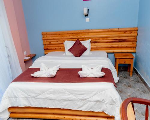 a bedroom with a large bed with a wooden headboard at Pinebreeze Holiday Resort in Nyali