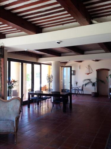 une grande pièce avec des tables, des chaises et des fenêtres dans l'établissement La Marine, à Luri