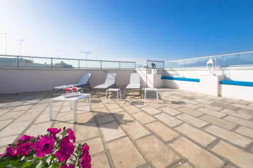 a patio with two chairs and a table and flowers at Case Vacanze Otranto in Otranto