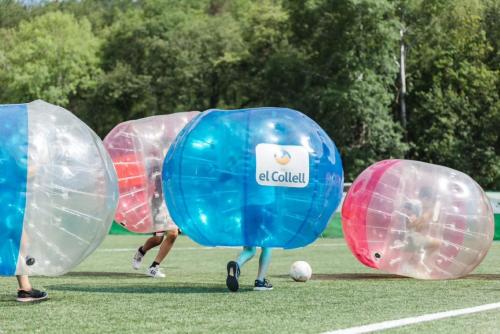 a group of people playing with inflated balls on a field at Hostal by El Collell TODO INCLUIDO in Sant Ferriol