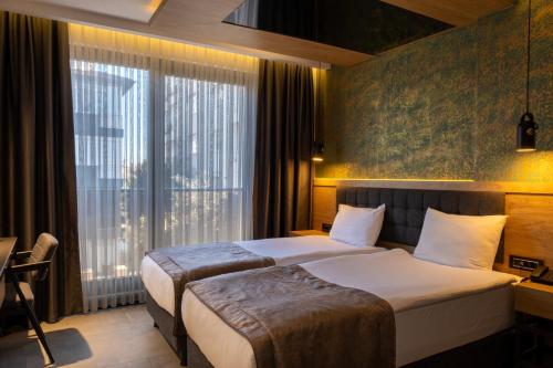 a hotel room with two beds and a window at Peramis Hotel & Spa in Antalya