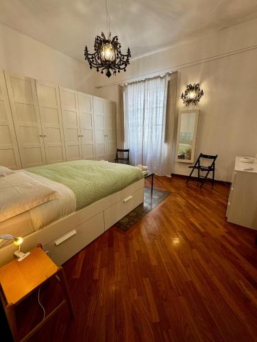 a bedroom with a large bed and a chandelier at Appartamento "Roma 148" in Syracuse
