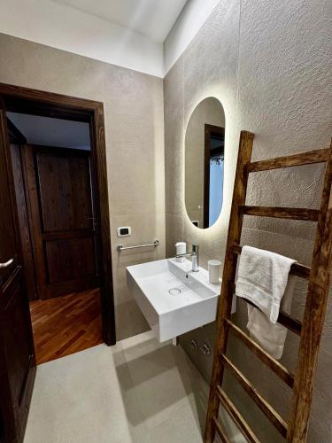 a bathroom with a sink and a mirror and a ladder at Appartamento "Roma 148" in Syracuse