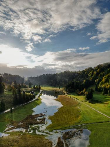 an aerial view of a golf course with a river at Heutaler Hof - Hotel im Naturidyll in Unken