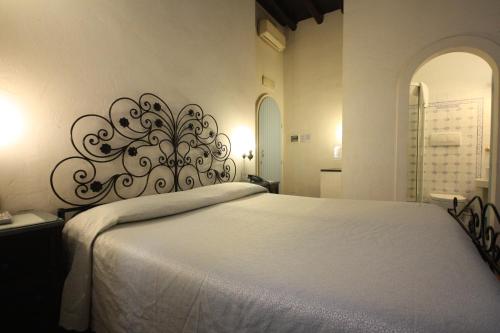 um quarto com uma cama branca e uma cabeceira de metal em Hotel Termini em Roma