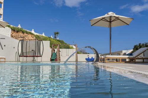 a pool with a water slide and an umbrella at Elysian Villa 2 With Private Pool in Roumelí