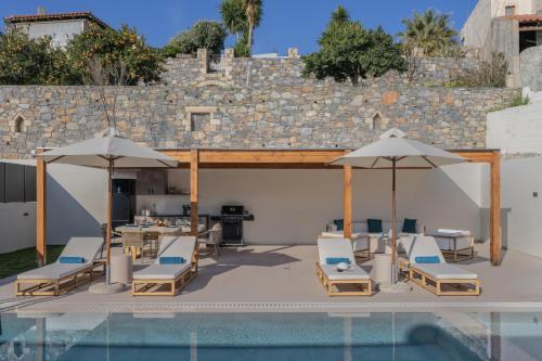 a patio with chairs and umbrellas next to a pool at Elysian Villa 2 With Private Pool in Roumelí